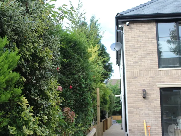 Satellite dish discreetly mounted on the side wall of a residential property