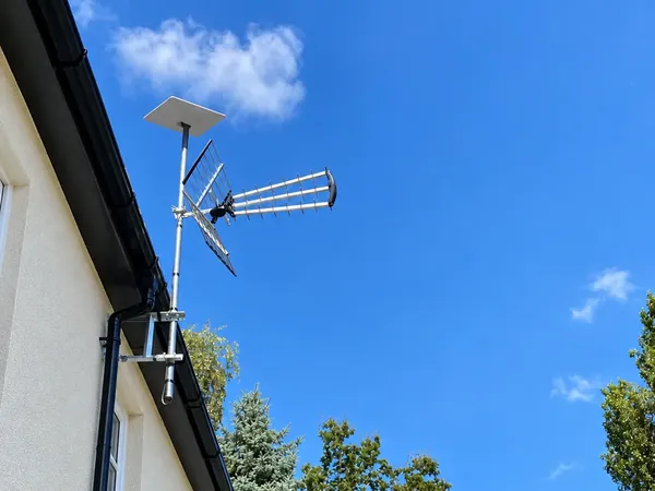 High-gain TV aerial mounted on an external wall bracket with a Starlink dish above