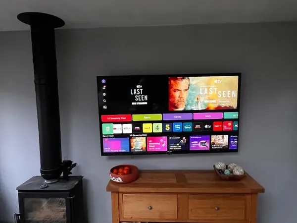 Flat-screen television professionally wall mounted above a wooden cabinet