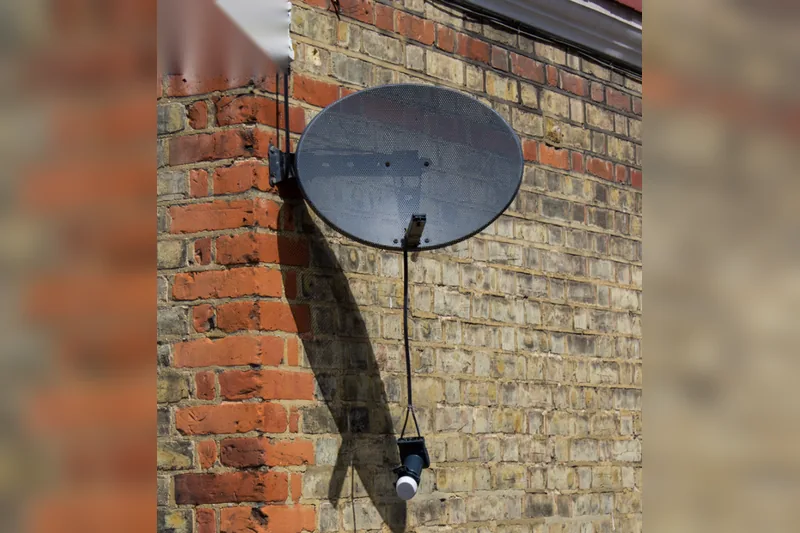 atellite dish with detached LNB hanging below the reflector, causing loss of satellite signal.
